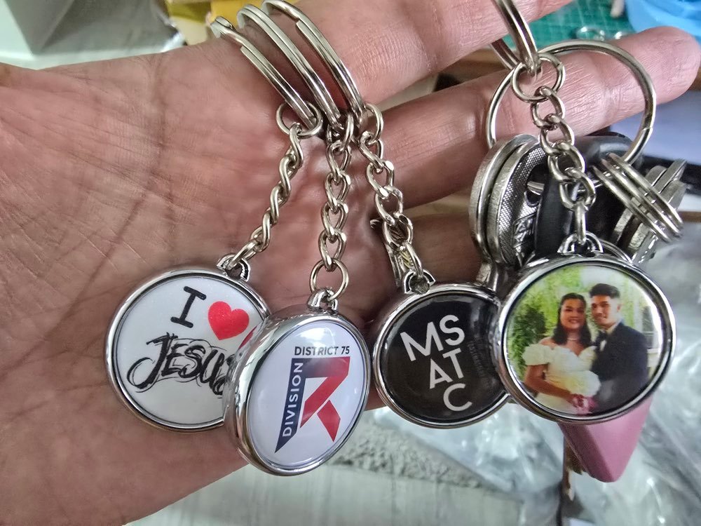 Personalized photo and logo keychains held in hand