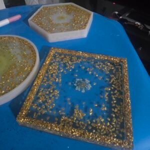 Hexagon, square, and oval resin coasters with gold leaf and a pressed flower