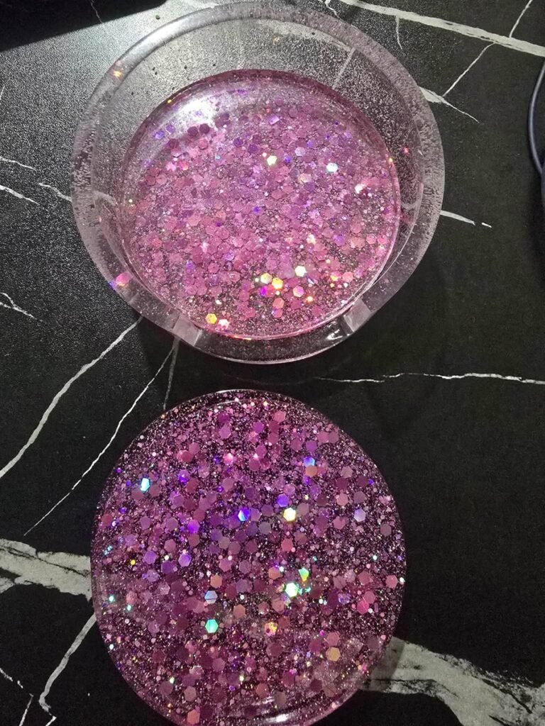 Two round resin coasters in light and deep pink glitter